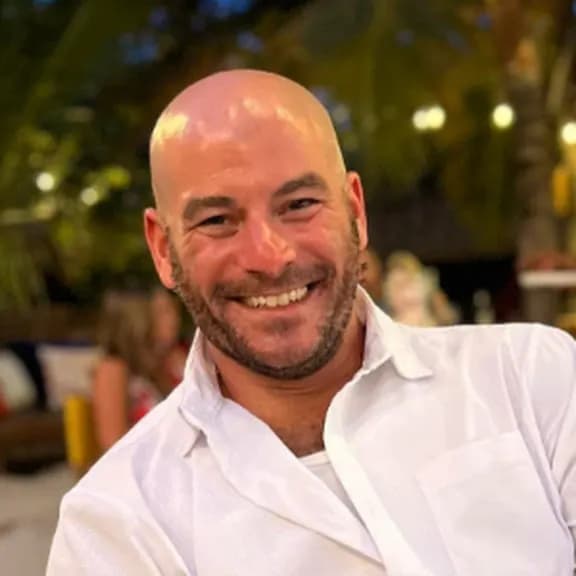 Jordan Rubin, New York Property Tax Consultant, headshot of a bald caucasian man with a beard in a white shirt